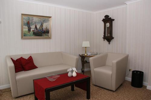 a living room with a couch and a chair at Hotel Beckröge in Cuxhaven