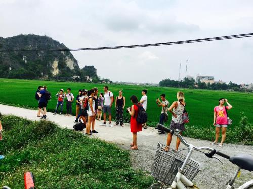 a group of people standing on a path near a field at Tam Coc Friendly Homestay in Ninh Binh