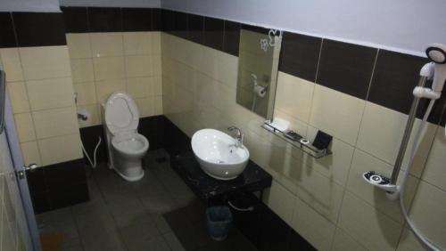 a bathroom with a toilet and a sink at Micasa Hotel Labuan in Labuan