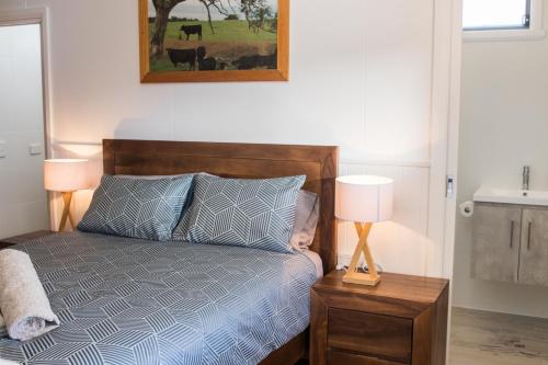 a bedroom with a bed and two lamps on a night stand at Mudgee Apartments on Horatio Street in Mudgee