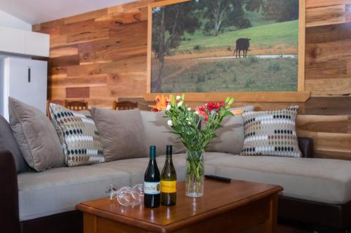 a living room with a couch and a table with wine bottles at Mudgee Apartments on Horatio Street in Mudgee