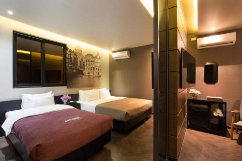 een hotelkamer met 2 bedden en een raam bij 2 Heaven Hotel Seomyeon in Busan