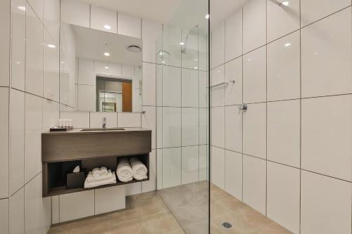 a bathroom with a shower and a sink and a mirror at Best Western Plus North Lakes Hotel in North Lakes