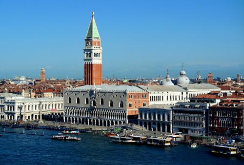 a large city with a clock tower on the water at Residence Delta in Rovigo