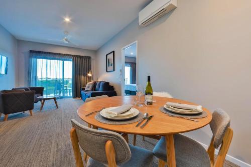 a living room with a wooden table and chairs at Best Western Plus North Lakes Hotel in North Lakes