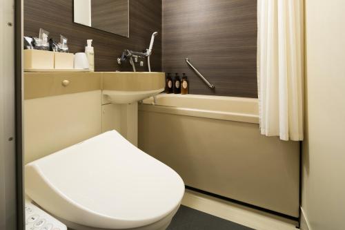 a bathroom with a toilet and a sink and a tub at Ark Hotel Okayama -ROUTE INN HOTELS- in Okayama