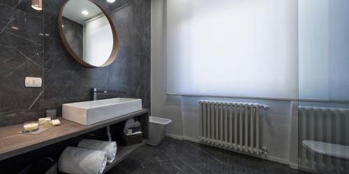 a bathroom with a sink and a mirror and a radiator at Suite Vogue Stazione in Voghera