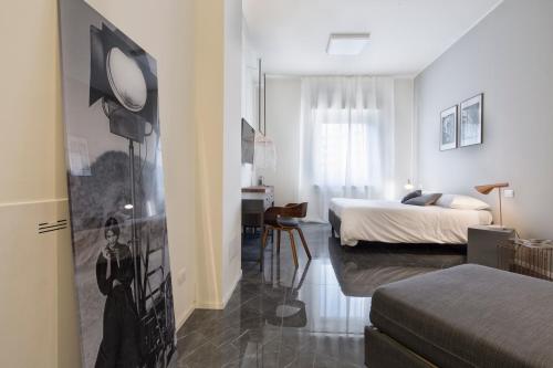 a bedroom with a bed and a desk in it at Suite Vogue Stazione in Voghera