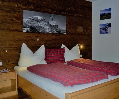 een slaapkamer met 2 bedden met rode en witte kussens bij Apartment Fernerblick in Neustift im Stubaital