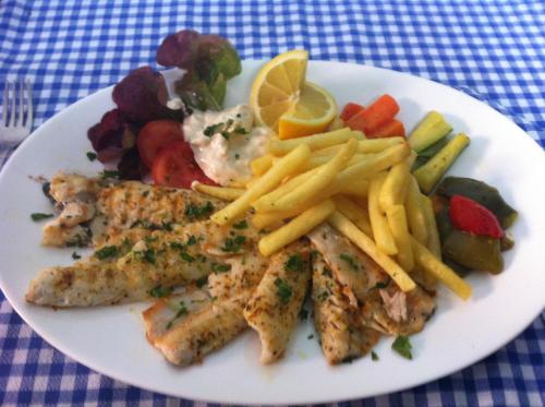 a plate of food with fish and french fries and vegetables at Osteria Battello in Caslano