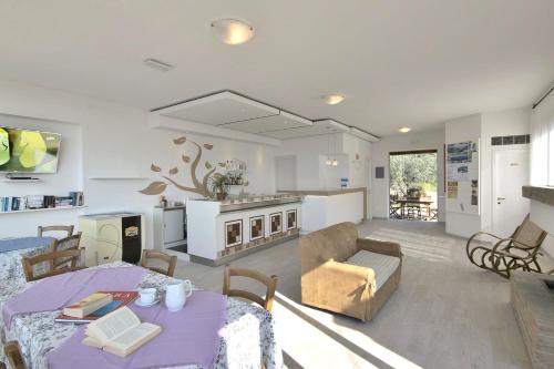 a living room with a table and a kitchen at Residenza Mini Hotel - RTA e Appartamenti Vacanza in Lacona