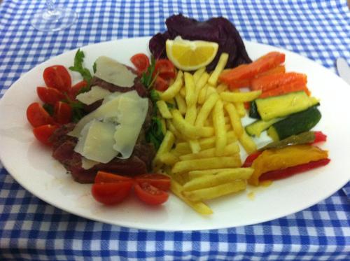 a plate of food with french fries and meat at Osteria Battello in Caslano