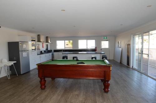 a kitchen with a pool table in the middle of a room at Sunset Beach Holiday Park in Geraldton