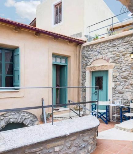 a house with a stone wall and a patio at Private studio in historic house in Lástros