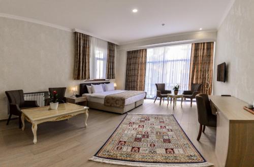 Habitación de hotel con cama y sala de estar. en Ammar Grand Hotel en Baku