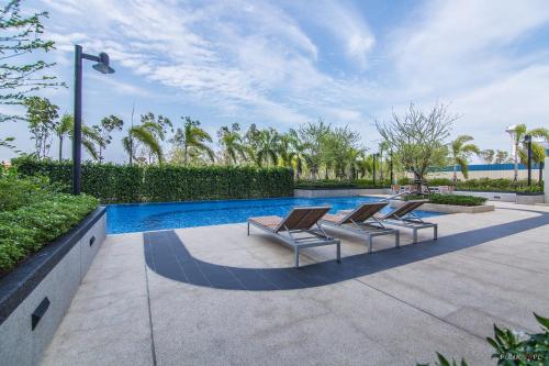 two lounge chairs and a swimming pool in a house at Lumpini LOFT condo 1705 in Ban Sahakham