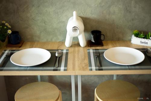 two white plates on a counter with two stools at Lumpini LOFT condo 1705 in Ban Sahakham