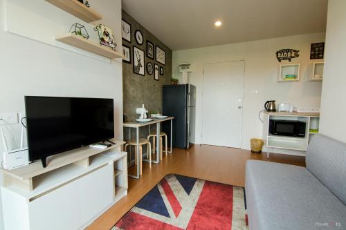 a living room with a large flat screen tv at Lumpini LOFT condo 1705 in Ban Sahakham