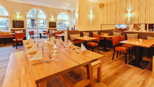 una gran mesa de madera en un restaurante con mesas y sillas en Hotel Thüringer Hof, en Sondershausen