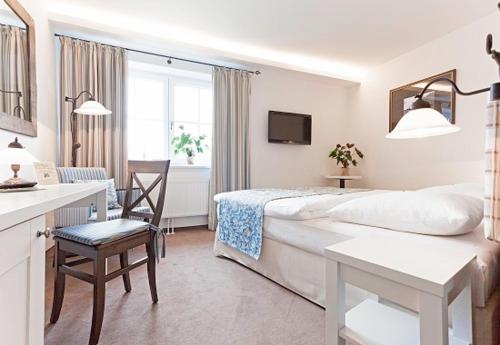 Habitación blanca con cama y mesa en Landhotel Jann Hinsch Hof en Winsen Aller