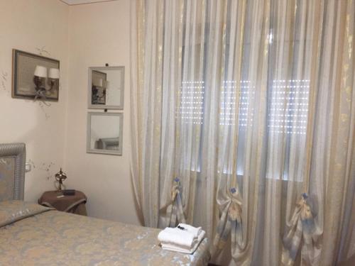 een slaapkamer met een bed en een raam met gordijnen bij Casa Stella in Bastia Umbra