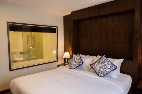 a bedroom with a large white bed with a large mirror at Elliebum Boutique Hotel in Chiang Mai