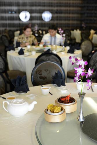 a table in a restaurant with people sitting at tables at Horizon Hotel in Kota Kinabalu