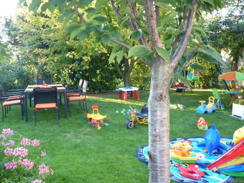 a garden with a table and chairs and a tree at Appartement Le Jardin in Lingolsheim