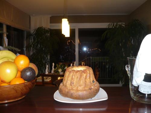 a cake sitting on a table next to a bowl of fruit at Appartement Le Jardin in Lingolsheim