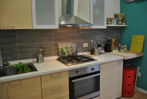 a kitchen with a stove top oven next to a sink at Balarm - Hostel and Bar in Palermo