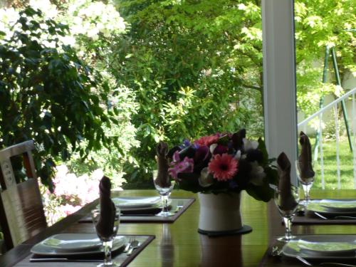 een tafel met een vaas met bloemen erop bij Appartement Le Jardin in Lingolsheim
