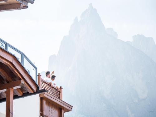 two people sitting on a balcony looking at a mountain at Apartment Sella in Siusi