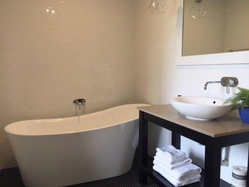 a bathroom with a white tub and a sink at Seabreeze Hotel in Nelson Bay