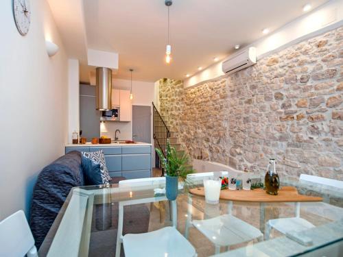 - un salon avec une table en verre et un mur en pierre dans l'établissement Casa Dora, à Rovinj