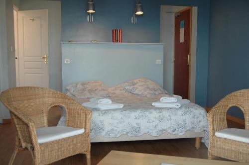 a bedroom with a bed with two wicker chairs at "Cap Riviera" Hotel & Restaurant Saint Aygulf in Saint-Aygulf