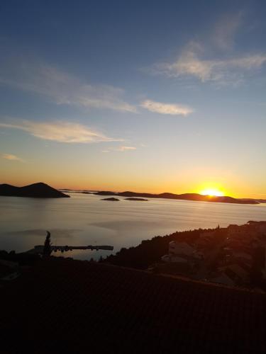 a sunset over a large body of water at Lavender Apartments in Drage
