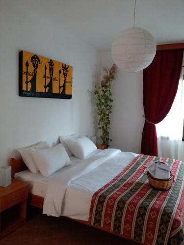 een slaapkamer met een bed met witte lakens en een lamp bij Kilim Hotel in Dalyan