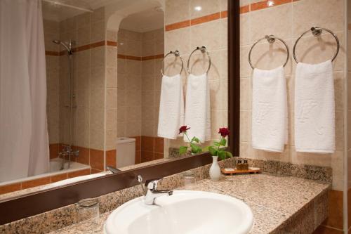 a bathroom with a sink and a mirror and towels at Kenzi Europa in Agadir