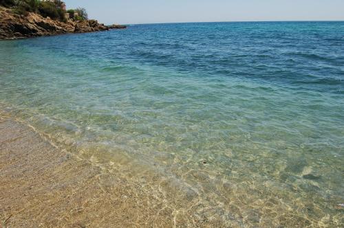 a beach with clear water and a rocky shore at "Cap Riviera" Hotel & Restaurant Saint Aygulf in Saint-Aygulf