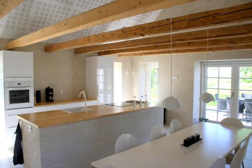 a kitchen and dining room with a table and chairs at Øvej 18 Holiday House in Ringsted