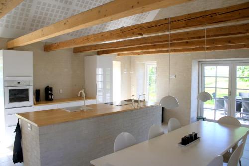 cocina y comedor con mesa y sillas en Øvej 18 Holiday House, en Ringsted