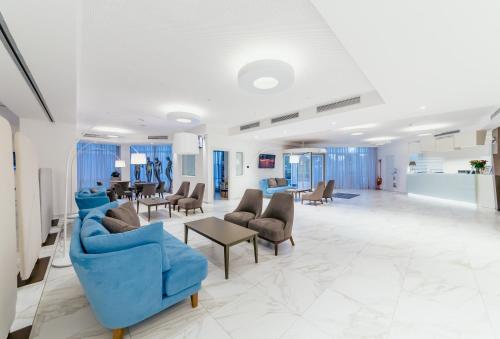 a waiting room with blue chairs and a table at Diamante MHotel in Collegno