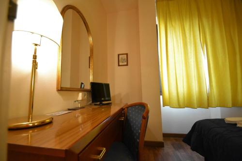 a hotel room with a desk with a computer on it at Hotel Posta in Cecina