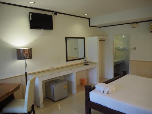 Habitación con cama y espejo en la pared. en The Hotel Nakhonsawan, en Nakhon Sawan