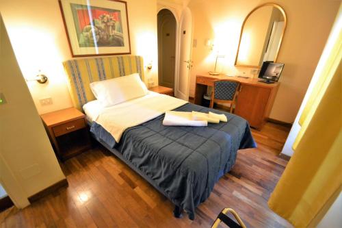 a hotel room with a bed and a desk at Hotel Posta in Cecina