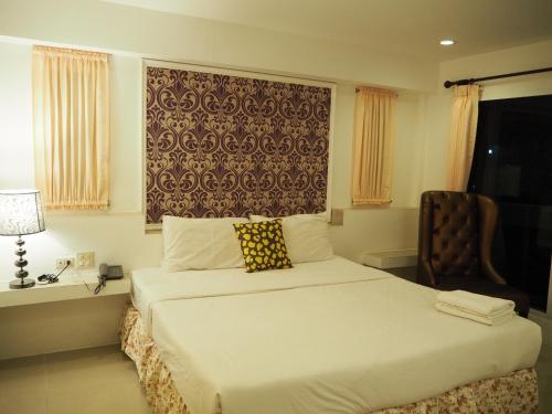 Un pat sau paturi într-o cameră la The Hotel Nakhonsawan
