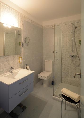 a bathroom with a sink and a shower and a toilet at Schwarzwaldhotel Sonne in Baden-Baden