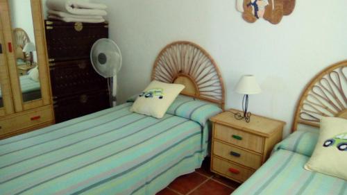 a bedroom with two beds and a dresser and a mirror at El Cerrillo in Agua Amarga