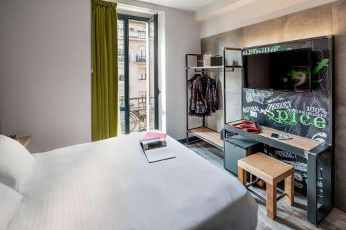 sypialnia z łóżkiem i telewizorem w pokoju w obiekcie Spice Hotel Milano w Mediolanie