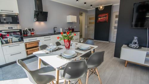 a kitchen and dining room with a table and chairs at Apartamenty Izerskie - ul. Cicha 13H-I in Świeradów-Zdrój